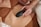 A person in brown underwear holds a dark device against their stomach. The scene is intimate and focused on personal care.