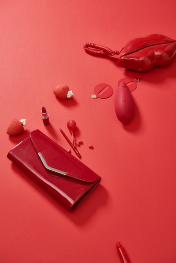 pink leather handbag beside red heart shaped ornament