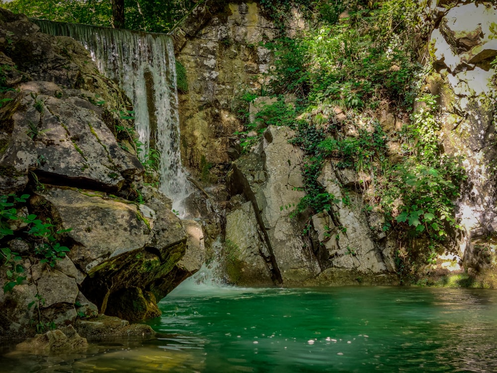 green and brown rocky mountain beside body of water during daytime