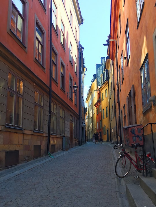 black bicycle parked beside brown concrete building during daytime in Gamla stan Sweden