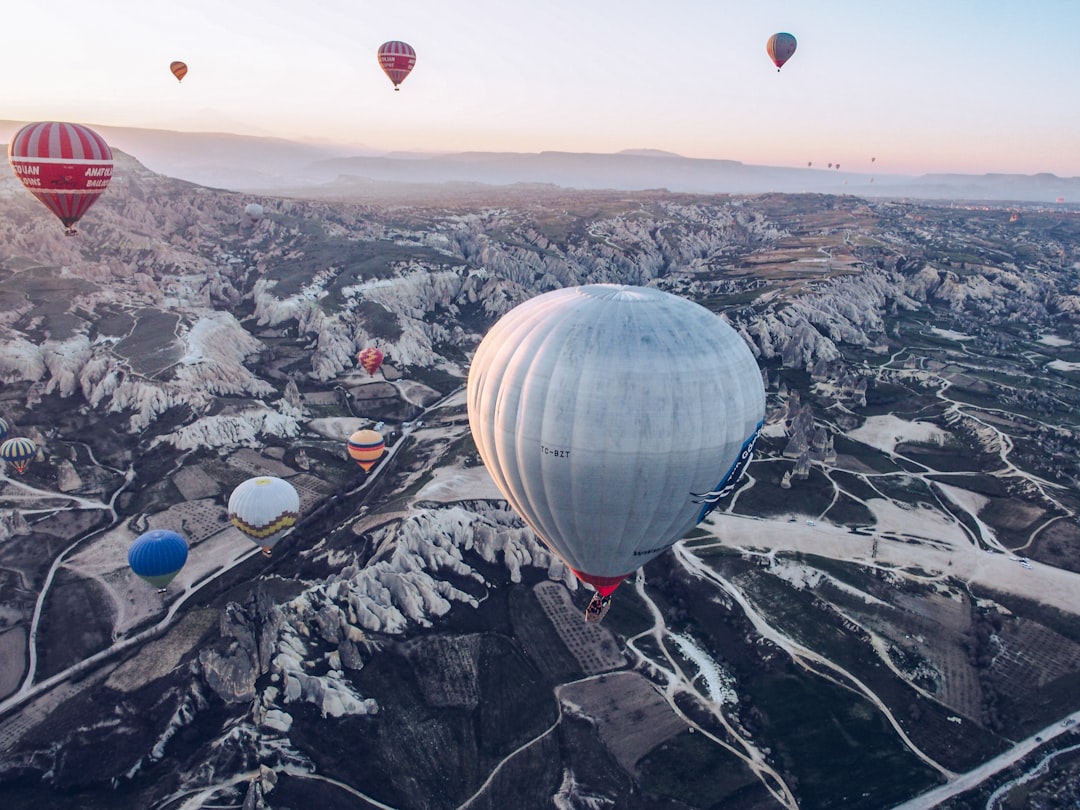 hot air balloons floating over the mountains during daytime