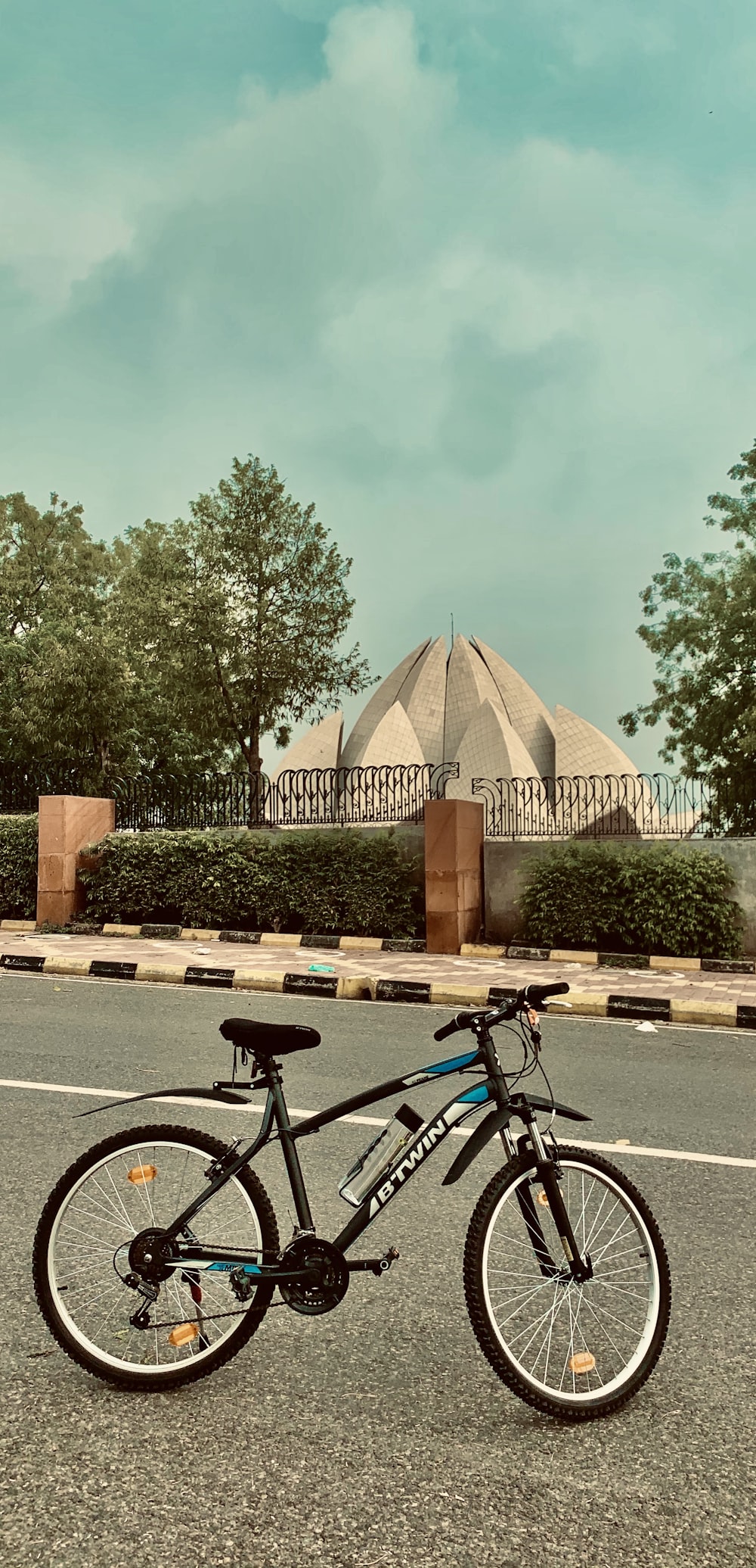 black bicycle parked near green trees during daytime