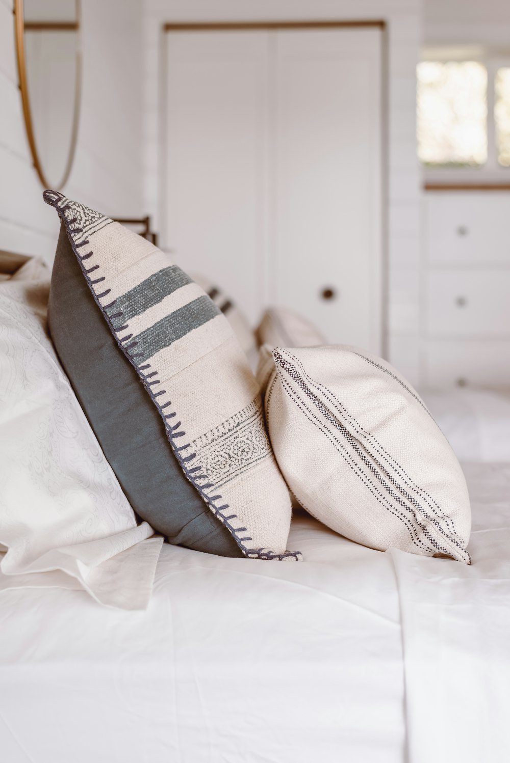 white and blue throw pillows on white bed