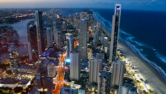 A sleek, modern satellite view of a coastal city at dusk with teal and navy overlays highlighting geospatial data points.
