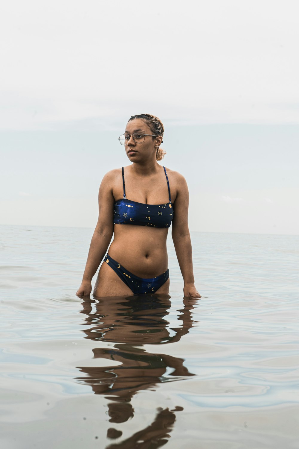 woman in blue bikini standing on water during daytime