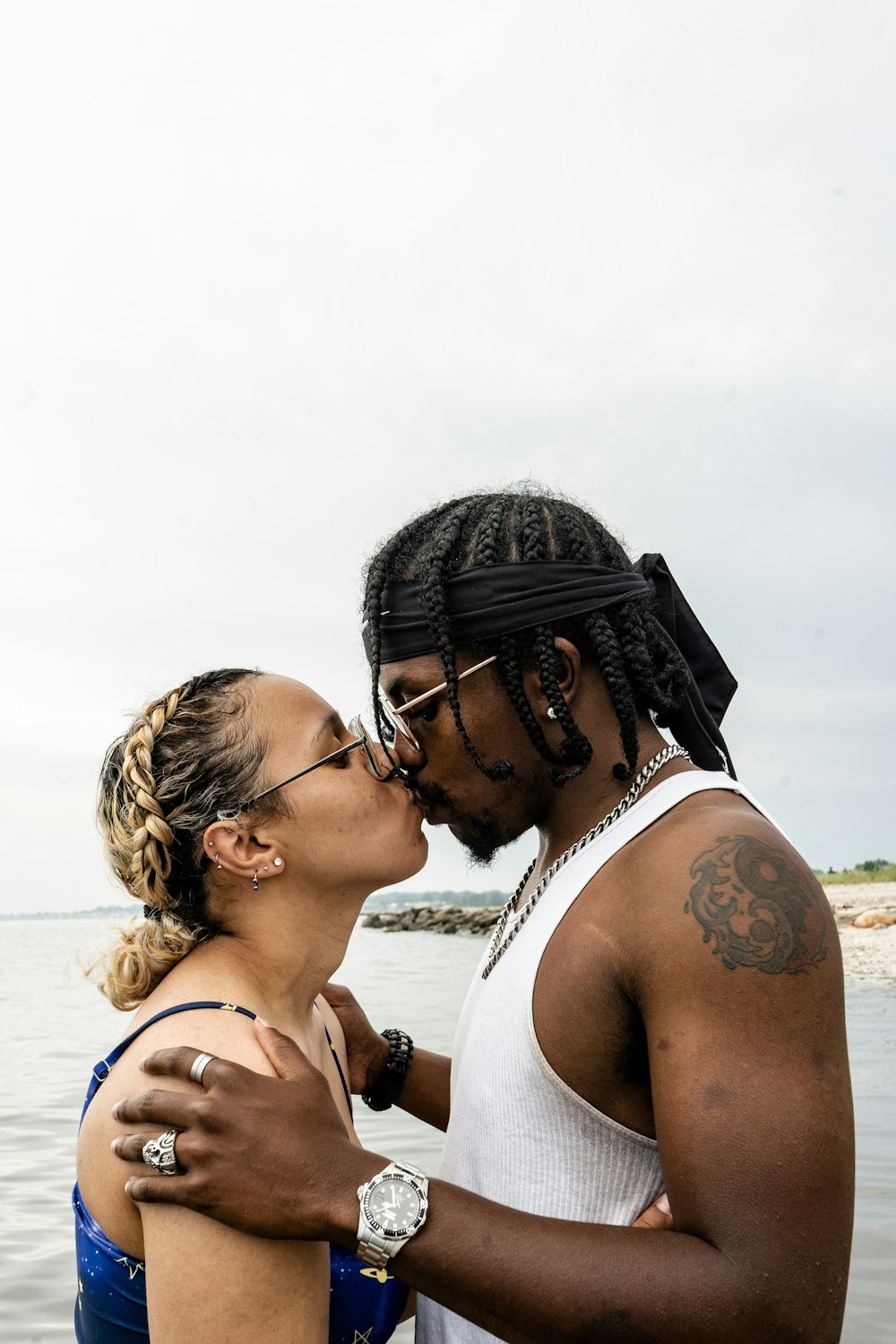 couple kissing near sea during daytime