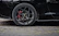 Close-up of a sleek, modified car wheel with a red brake caliper, highlighting performance and style.