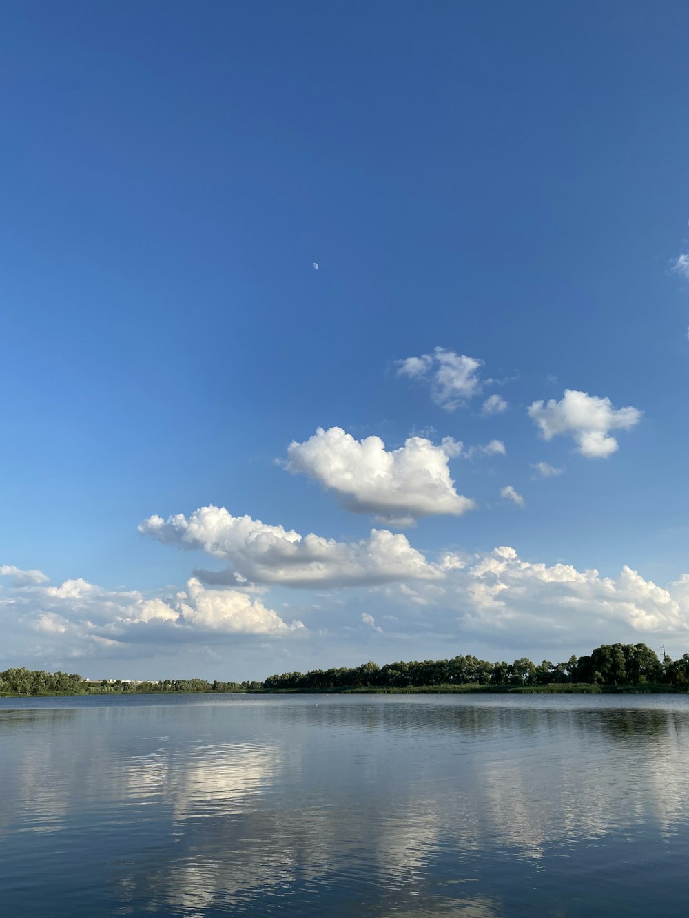 body of water under blue sky and white clouds during daytime