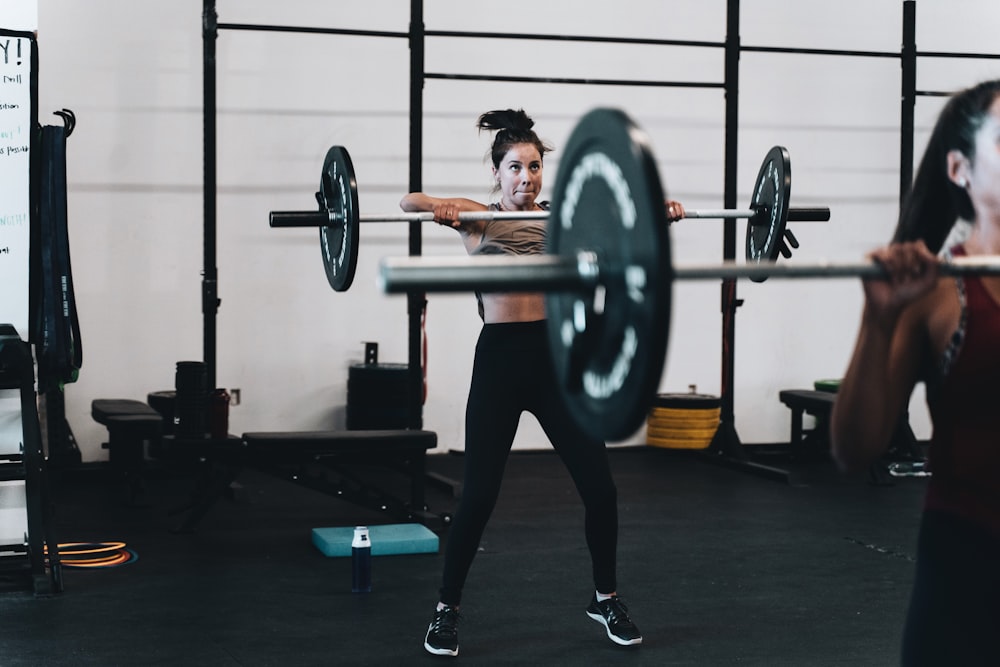 woman in black leggings and black tank top doing exercise