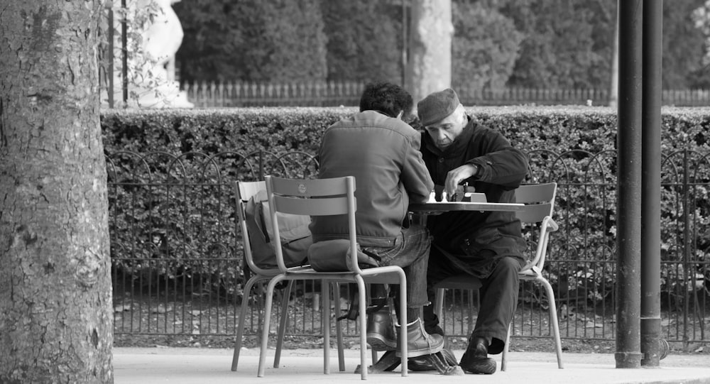 man in black suit sitting on chair