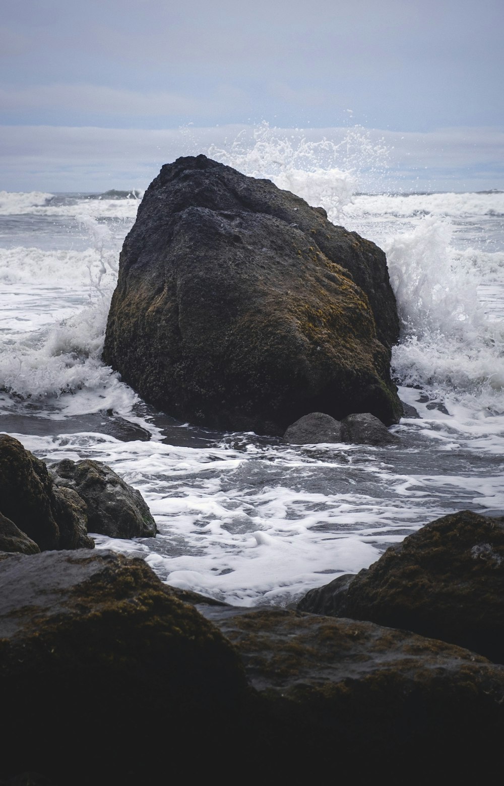 formação rochosa marrom na água do mar durante o dia