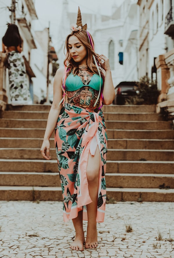 woman in green and red floral dress standing on brown concrete stairs during daytime