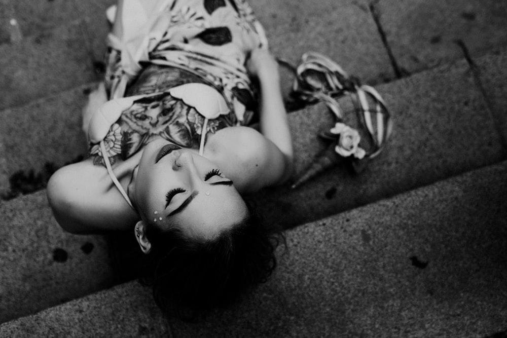 grayscale photo of woman lying on ground