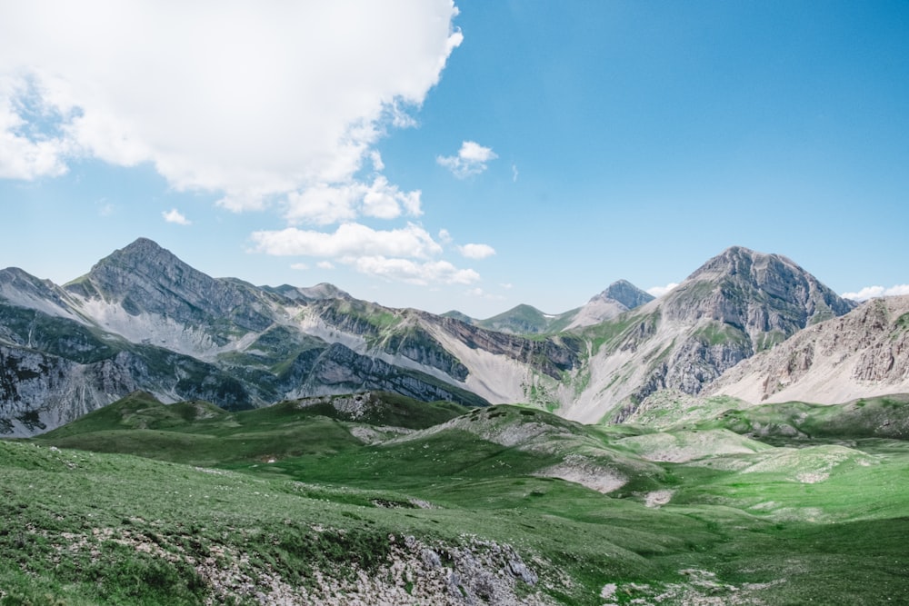 Montañas verdes y marrones bajo el cielo azul durante el día