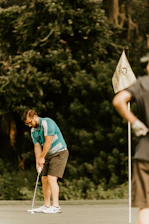 Close-up of a golfer focusing intensely while lining up a putt on a pristine green.