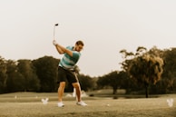 A golfer wearing a breathable, stylish polo shirt swinging on a sunny course.