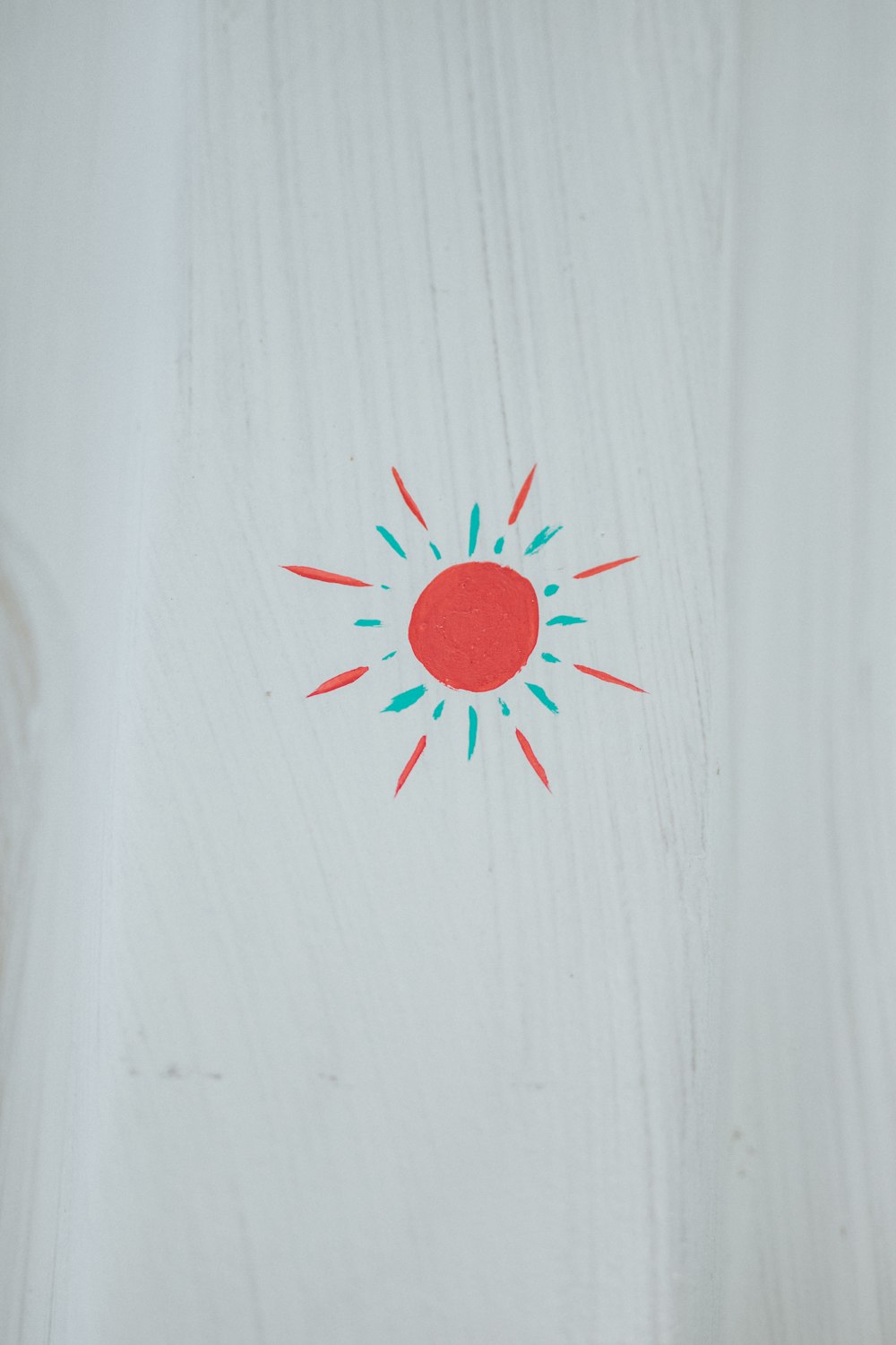 red round ornament on white wooden surface