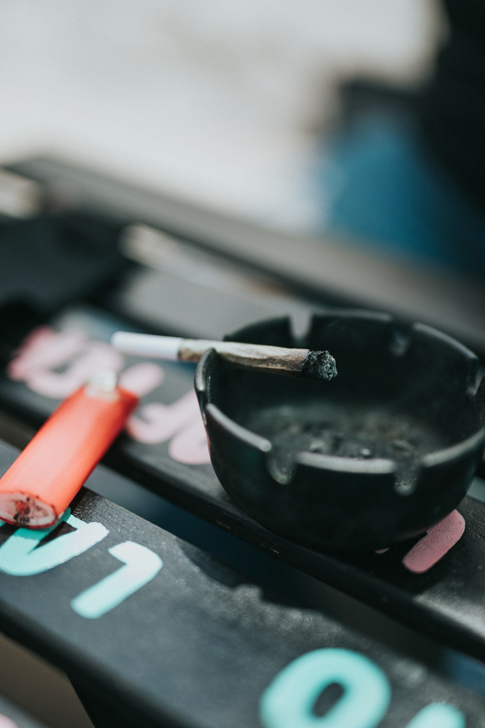 red cigarette butts on black round ashtray