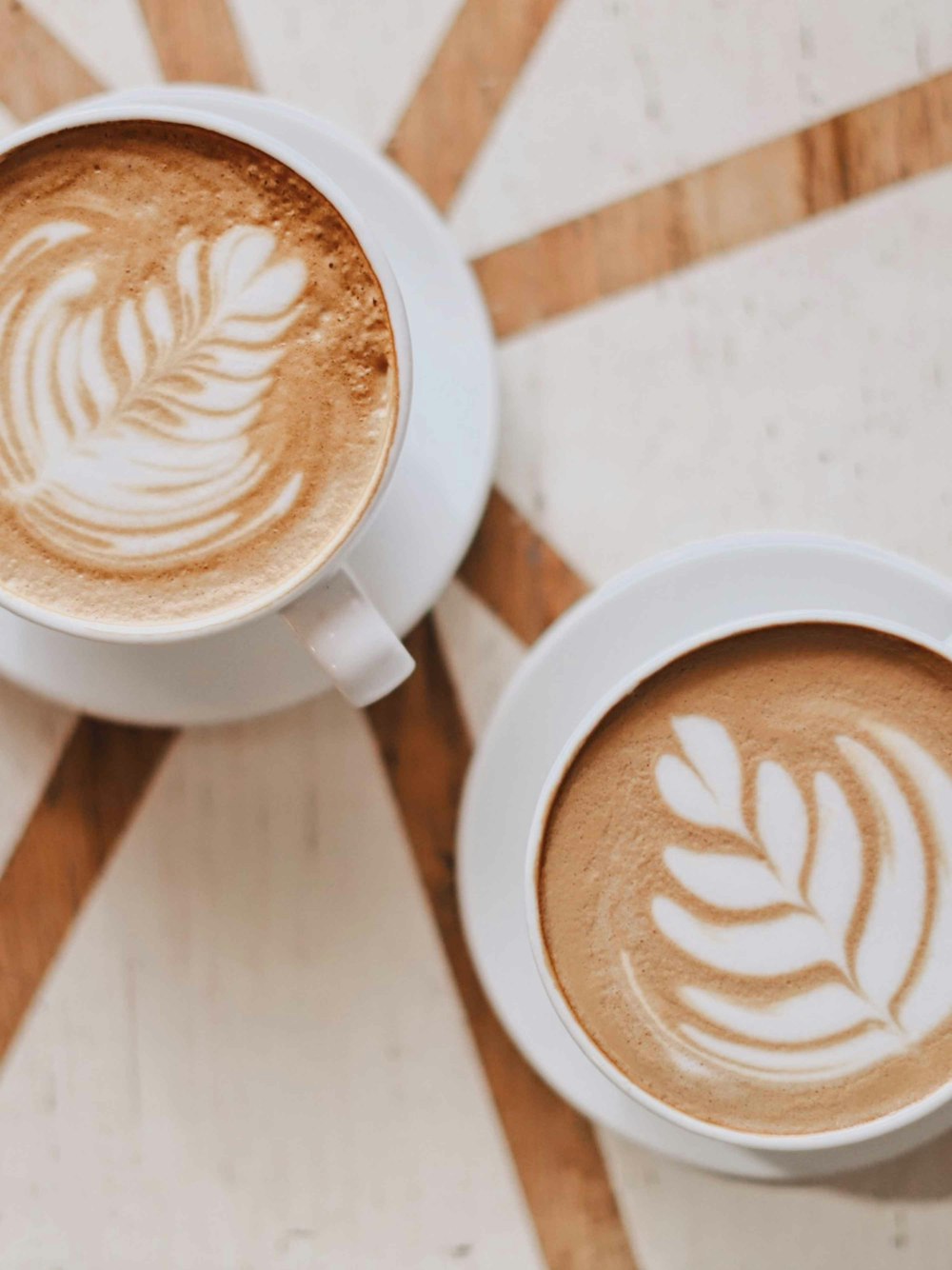 white ceramic mug with brown and white heart shaped coffee