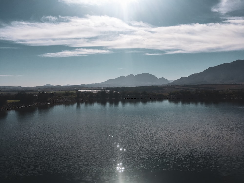 lake near mountain under blue sky during daytime