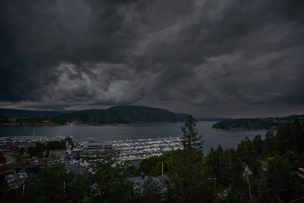 body of water near mountain under cloudy sky during daytime