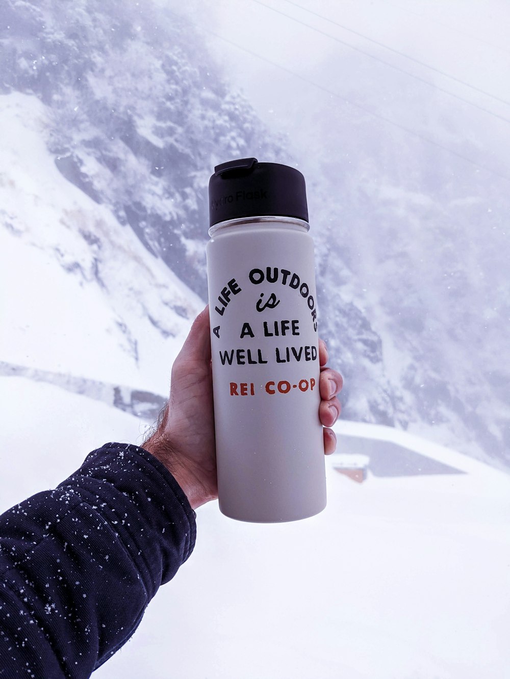 person holding white and black plastic bottle