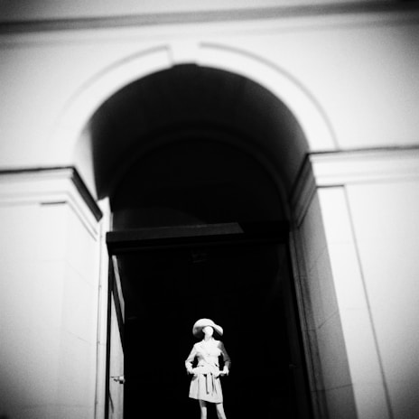 A stylish men's trench coat displayed on a mannequin in a modern boutique setting.