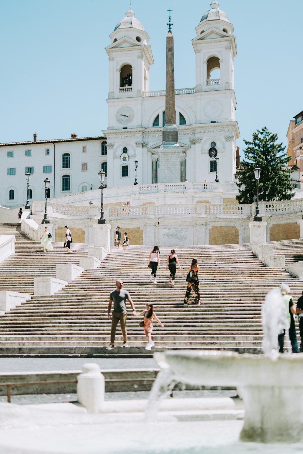 people walking on gray concrete stairs near white concrete building during daytime