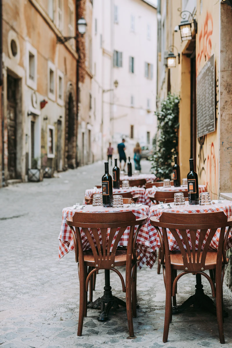 Terrasse einer Pizzeria mit rot-weiß karierten Tischdecken