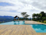 Private infinity pool overlooking lush green hills.