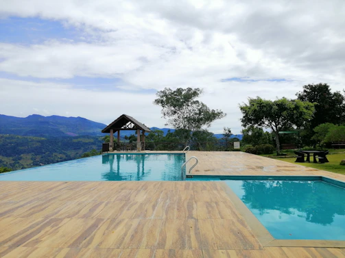Private infinity pool overlooking lush greenery under a clear blue sky
