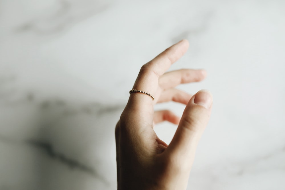 person wearing gold ring with diamond studded