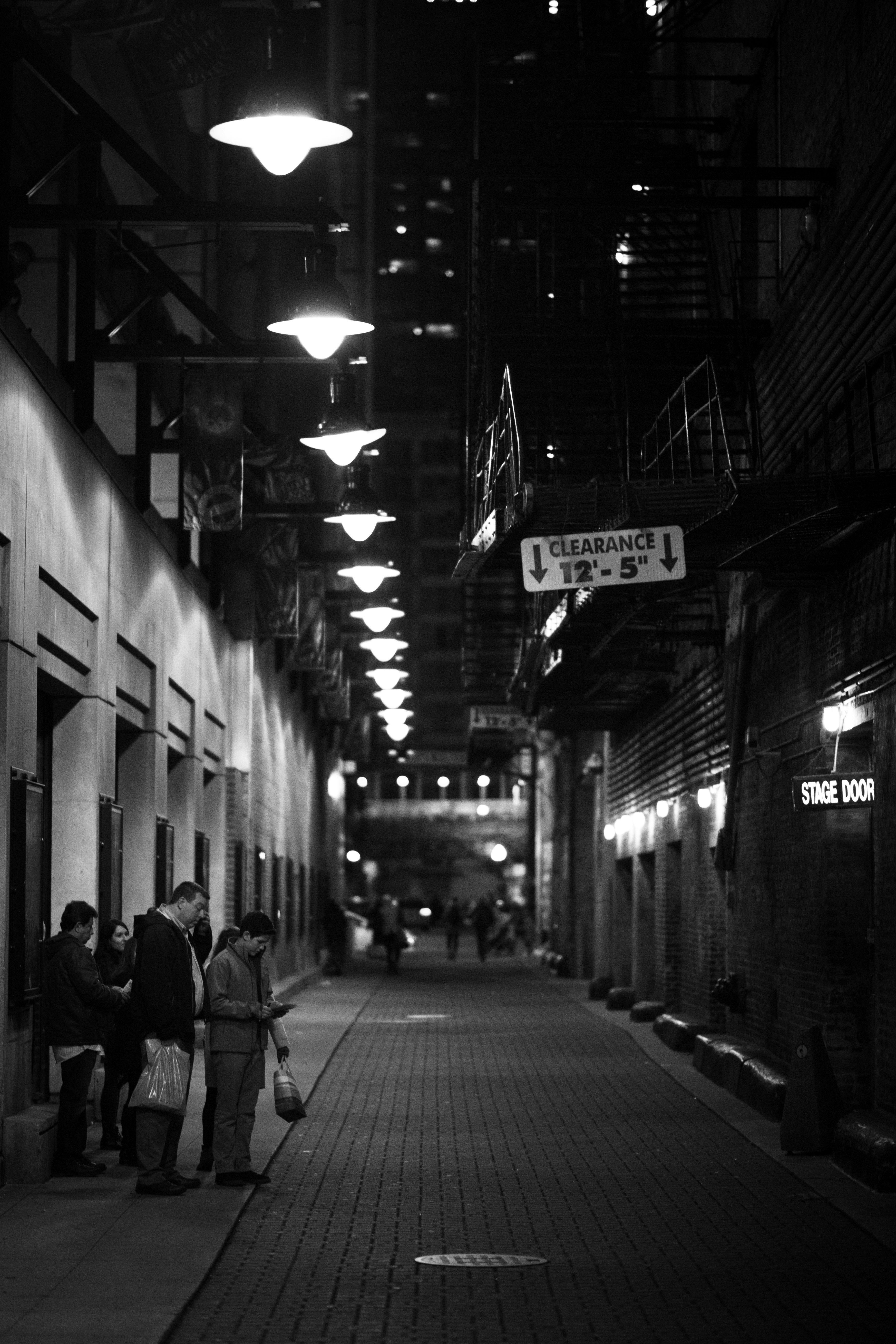 grayscale photo of people walking on sidewalk