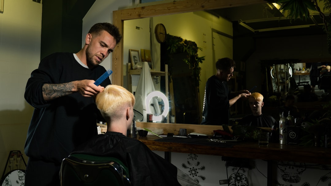 man in black suit sitting on barber chair