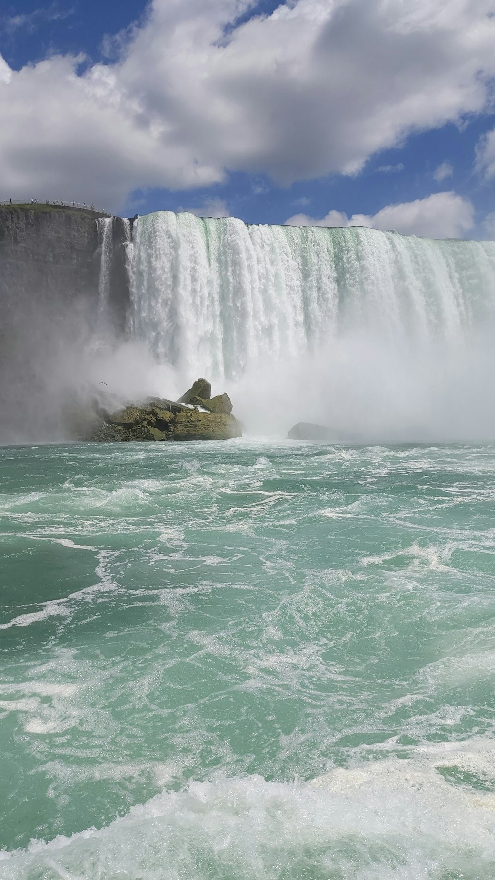 green and brown rock formation on water falls during daytime