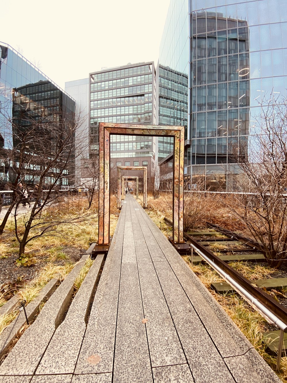 Carril de tren de madera marrón cerca de un edificio de cristal durante el día