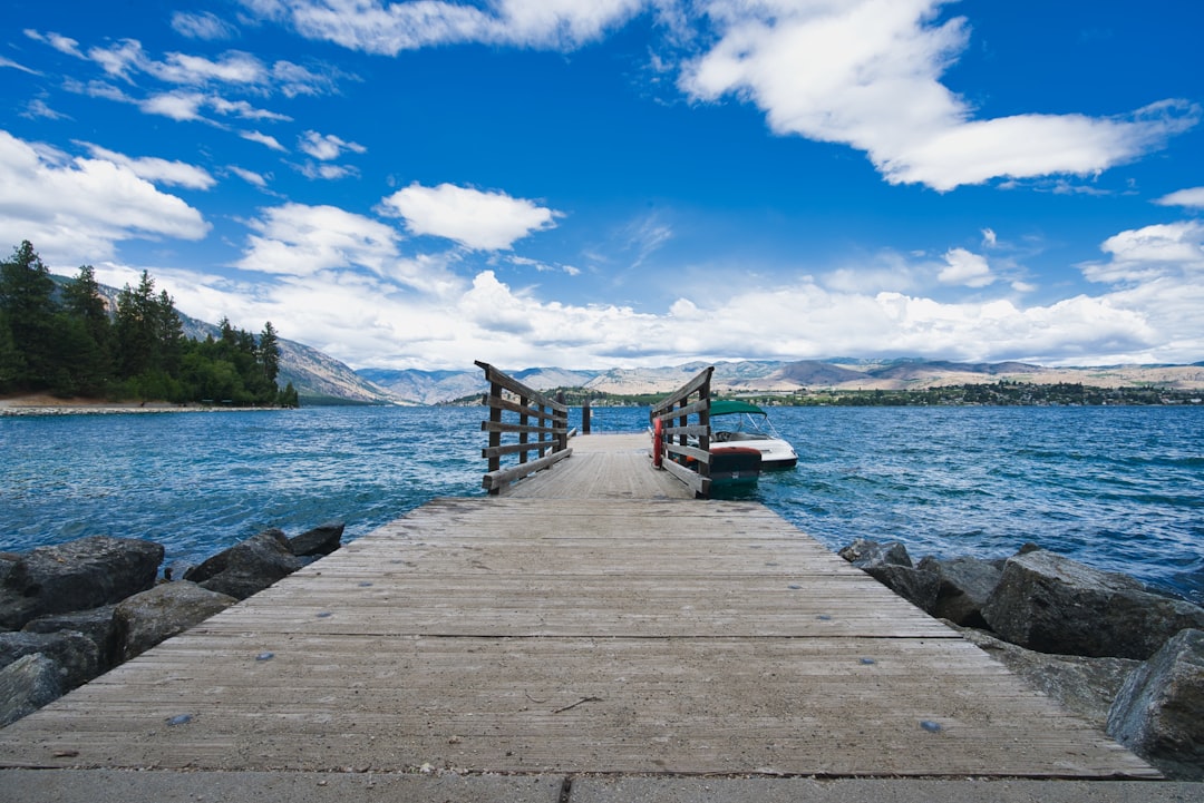 brown wooden dock on body of water under blue sky during daytime