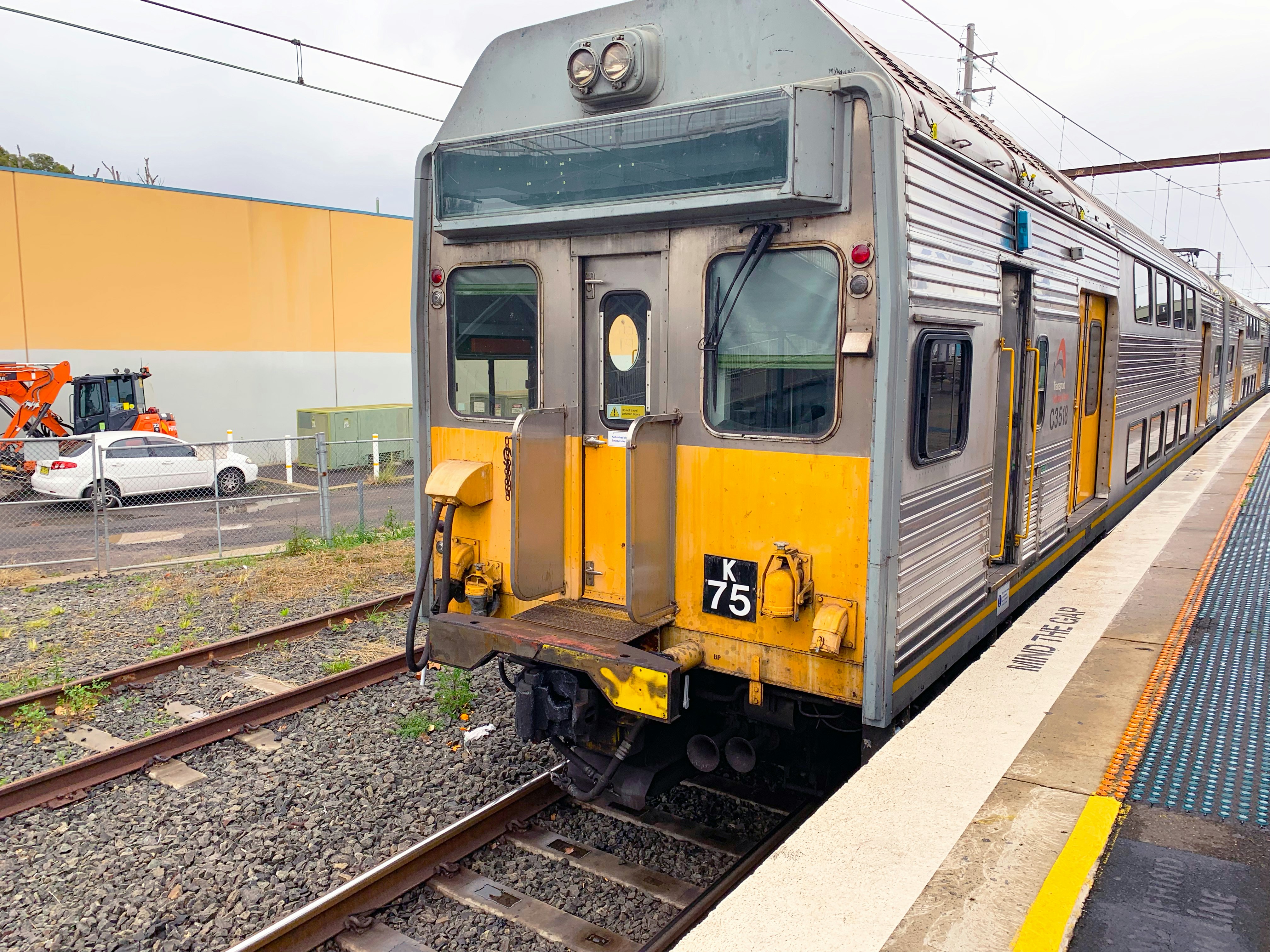 yellow and black train on rail tracks during daytime