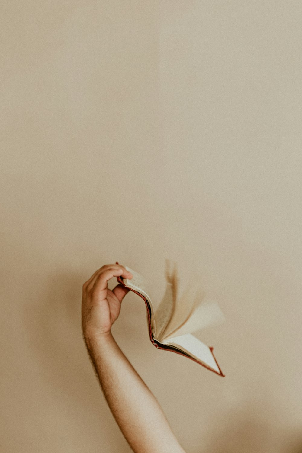 person holding white textile on white wall