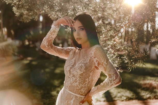 woman in beige floral dress standing near white string lights