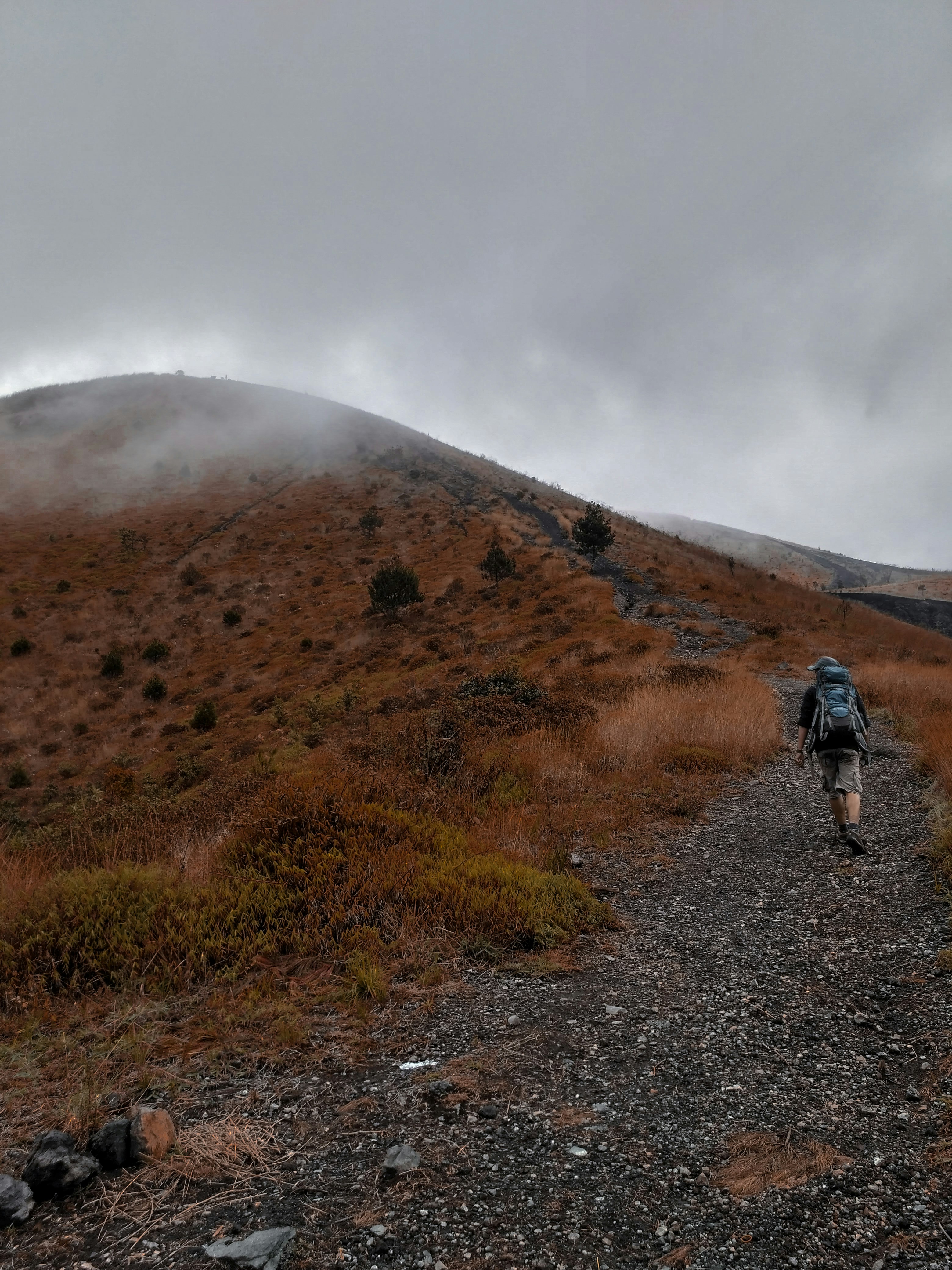 man in black jacket walking on dirt road