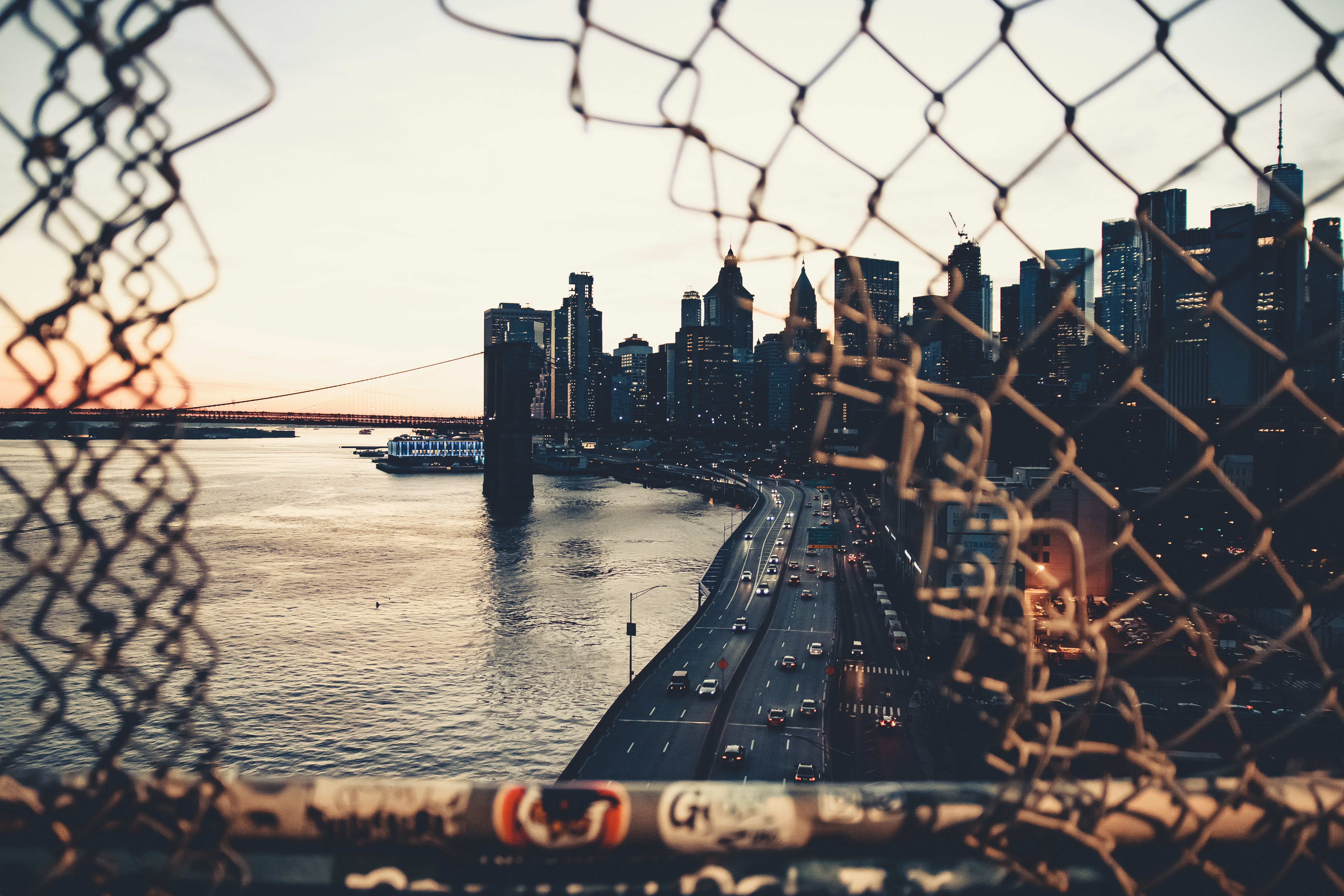 new york skyline and brookly bridge at sunset from manhattan bridge