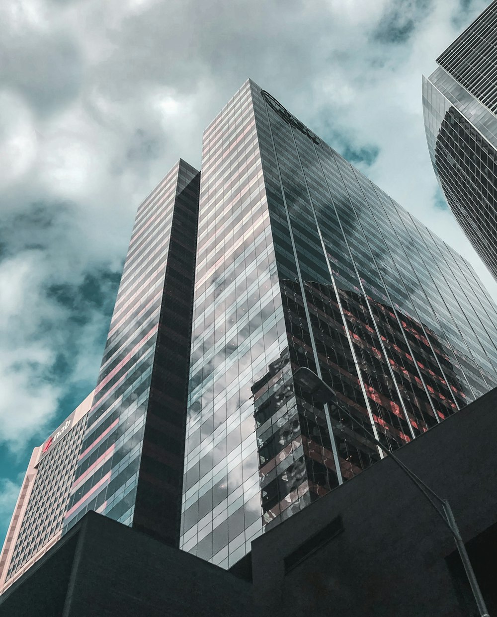 low angle photography of high rise building under cloudy sky during daytime
