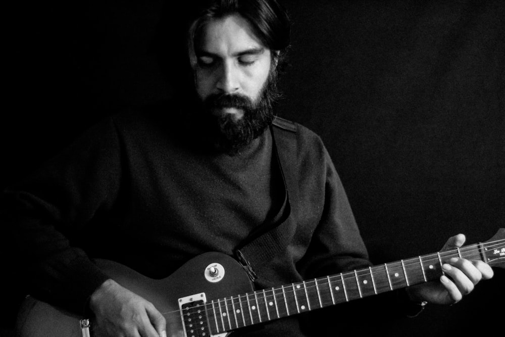 man in black shirt playing electric guitar