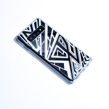 A sleek smartphone case with a vibrant geometric pattern displayed on a wooden table.