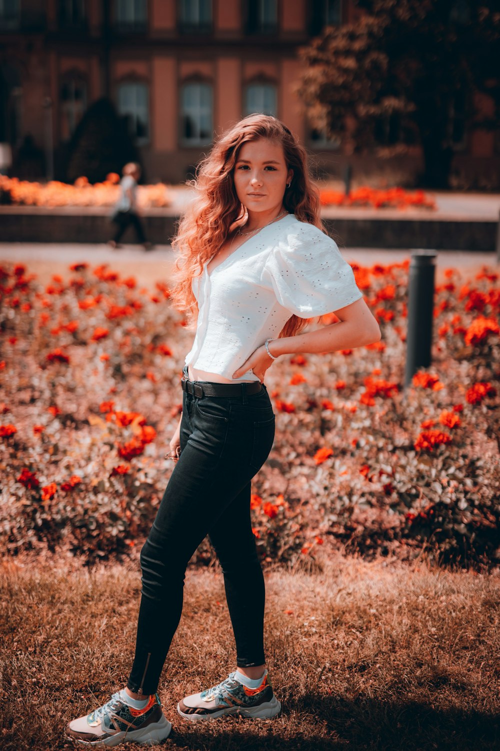 woman in white shirt and black pants standing on brown grass field during daytime