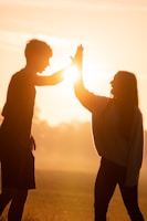 silhouette of man and woman holding hands during sunset
