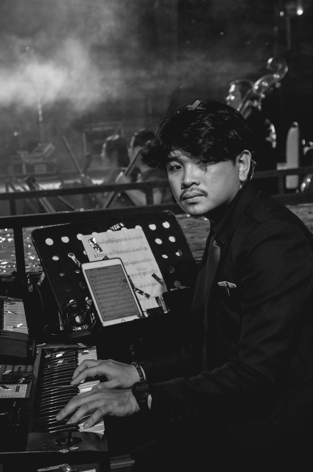 man in black coat playing piano