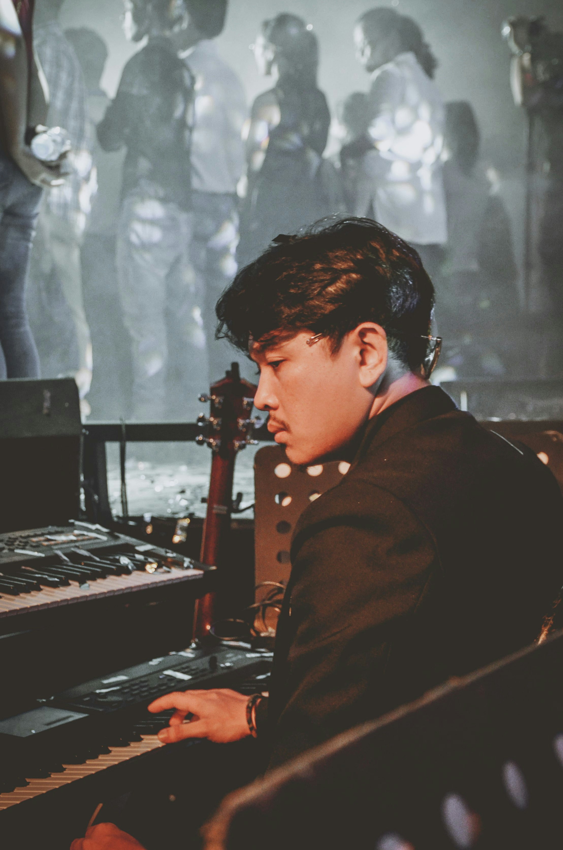 man in black coat playing piano