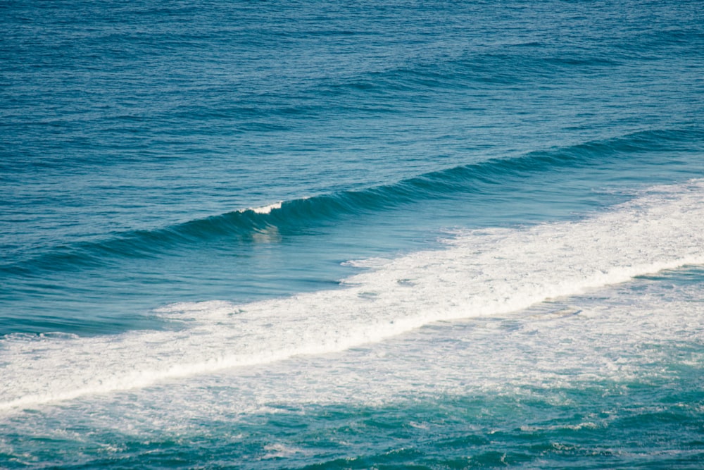 ocean waves crashing on shore during daytime